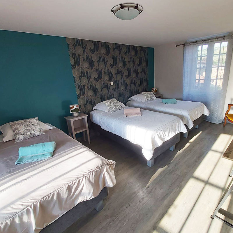 Chambre d’hôtes La Jade à Azé avec trois lits, en Bourgogne du Sud.