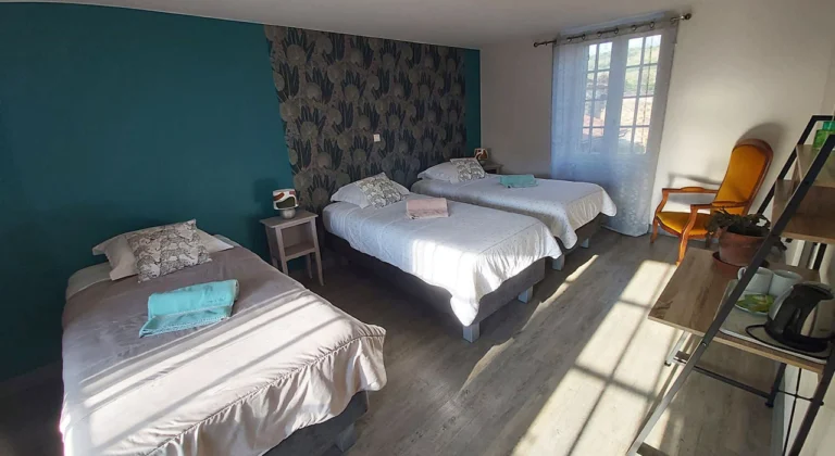 Chambre d’hôtes La Jade à Azé avec trois lits, en Bourgogne du Sud.